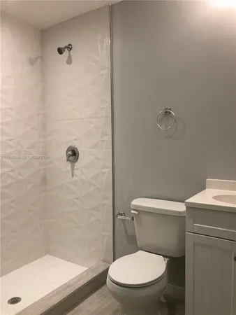 a white toilet sitting next to a bath tub