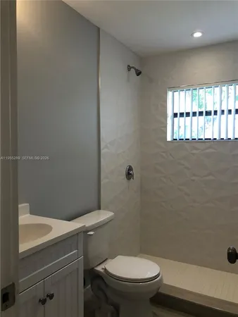 a white toilet sitting next to a bath tub