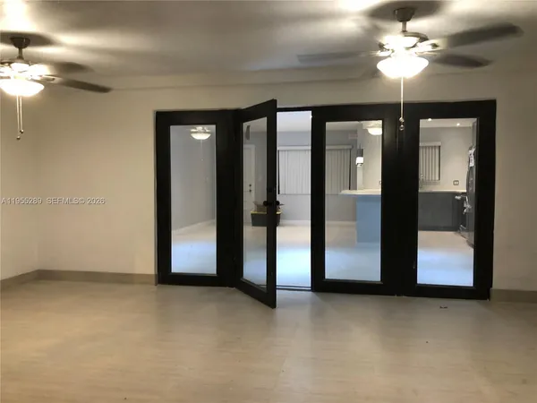 a view of an empty room with a chandelier fan
