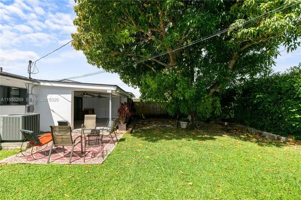 a view of a backyard with table and chairs and floor to ceiling window
