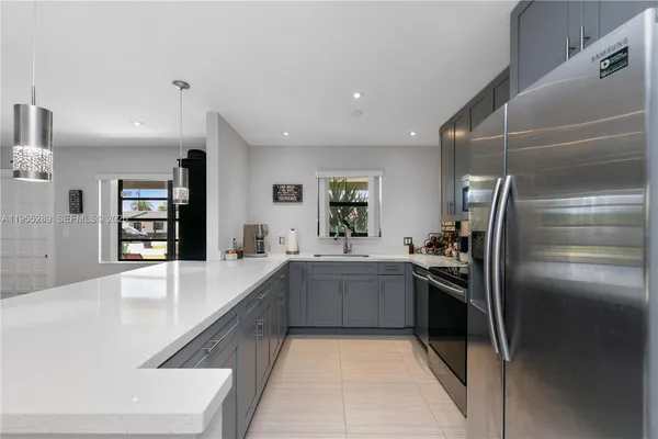 a large kitchen with stainless steel appliances lots of counter space and a sink
