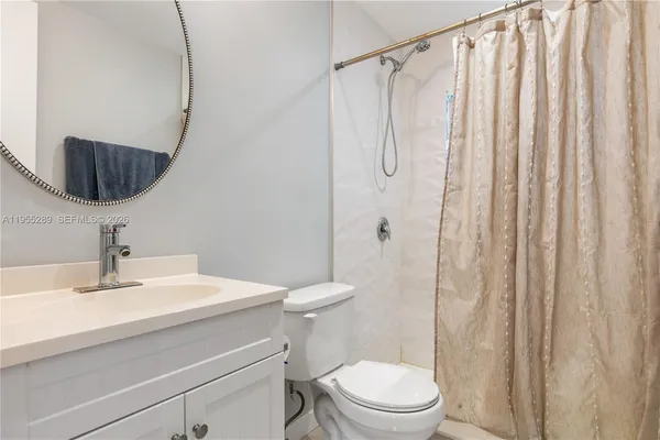 a bathroom with a sink a toilet and shower curtain