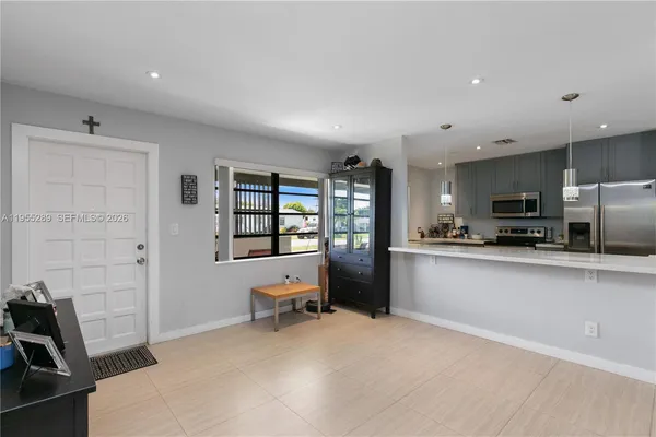 a kitchen with stainless steel appliances a refrigerator and wooden floor