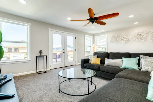 a living room with furniture a ceiling fan and a window
