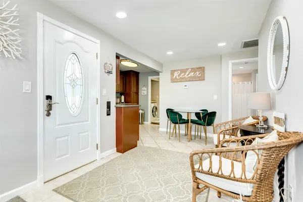 a living room with furniture a dining table and a refrigerator