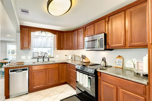 a kitchen with stainless steel appliances granite countertop a sink stove microwave and cabinets