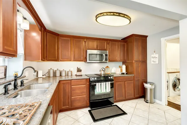 a kitchen with stainless steel appliances granite countertop a sink stove top oven and cabinets