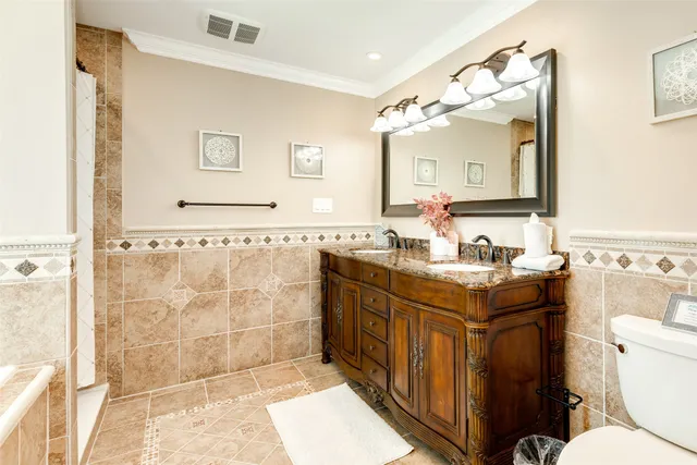 a bathroom with a granite countertop sink toilet a mirror and shower