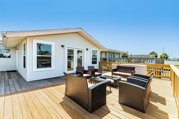 a view of a patio with couches potted plants and wooden floor