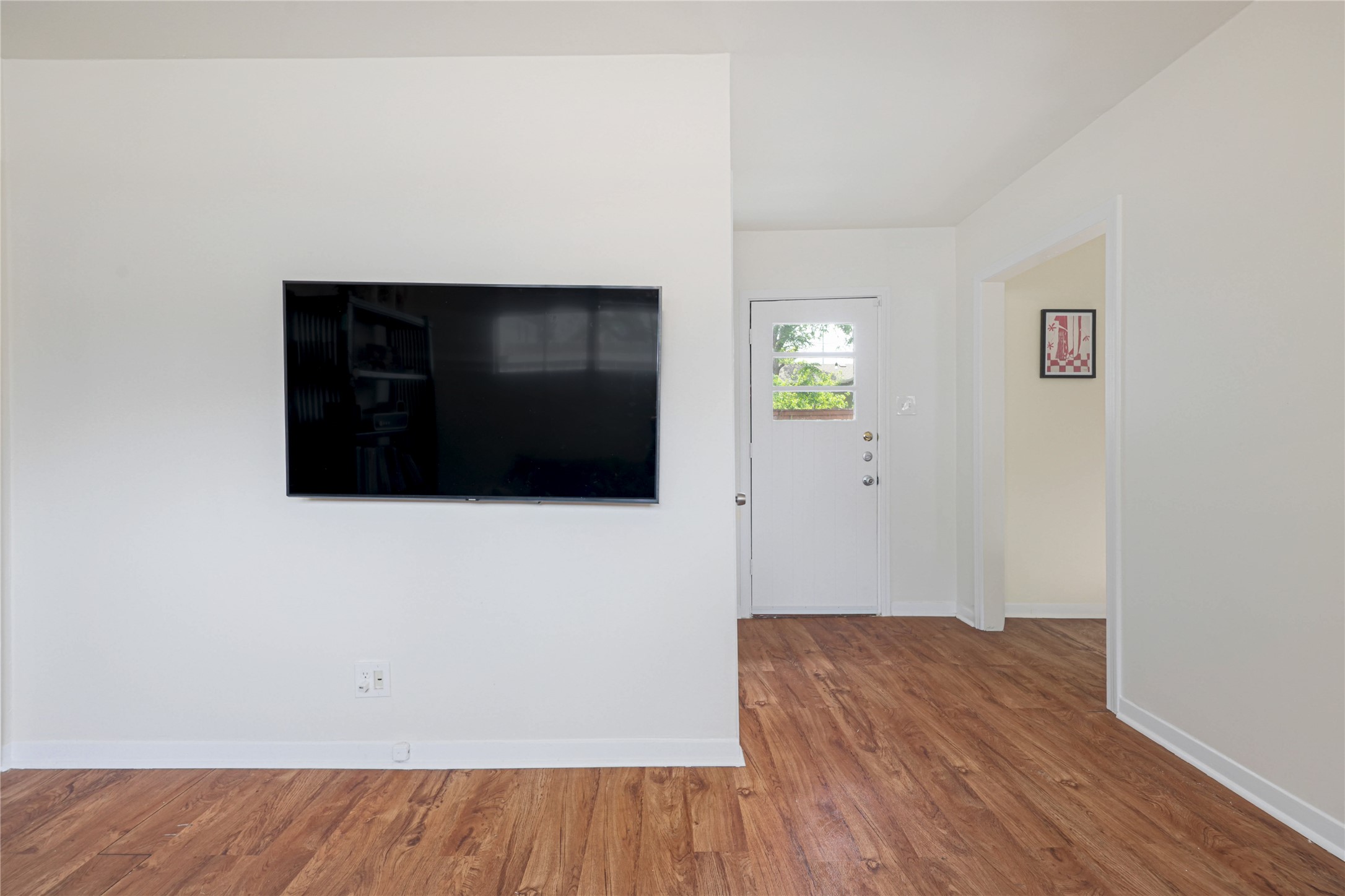 4607 Evans Avenue, Unit B Austin, TX 78751 - Photo 6 of 34 Interior space featuring wood-finish flooring, white walls, and a white entry door with frosted glass