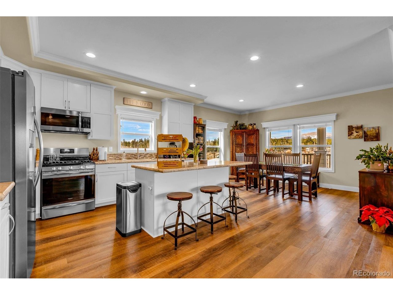 108 Sun Rock Road, Unit A Fairplay, CO 80440 - Photo 1 of 49 a kitchen with stainless steel appliances granite countertop a stove top oven a sink a dining table and chairs with wooden floor