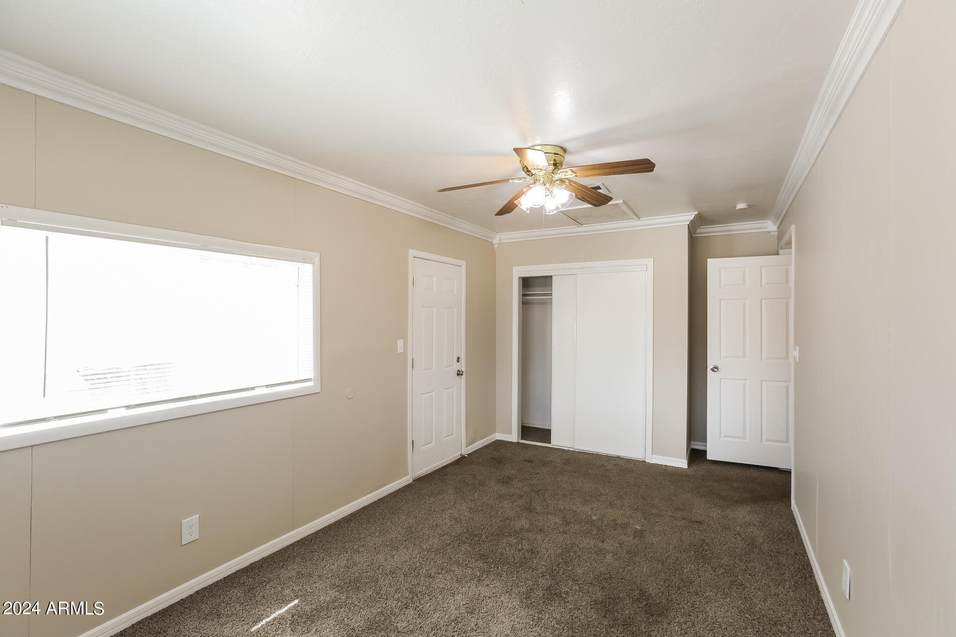 6963 West Pierson Street Phoenix, AZ 85033 - Photo 13 of 21 an empty room with a window and a ceiling fan
