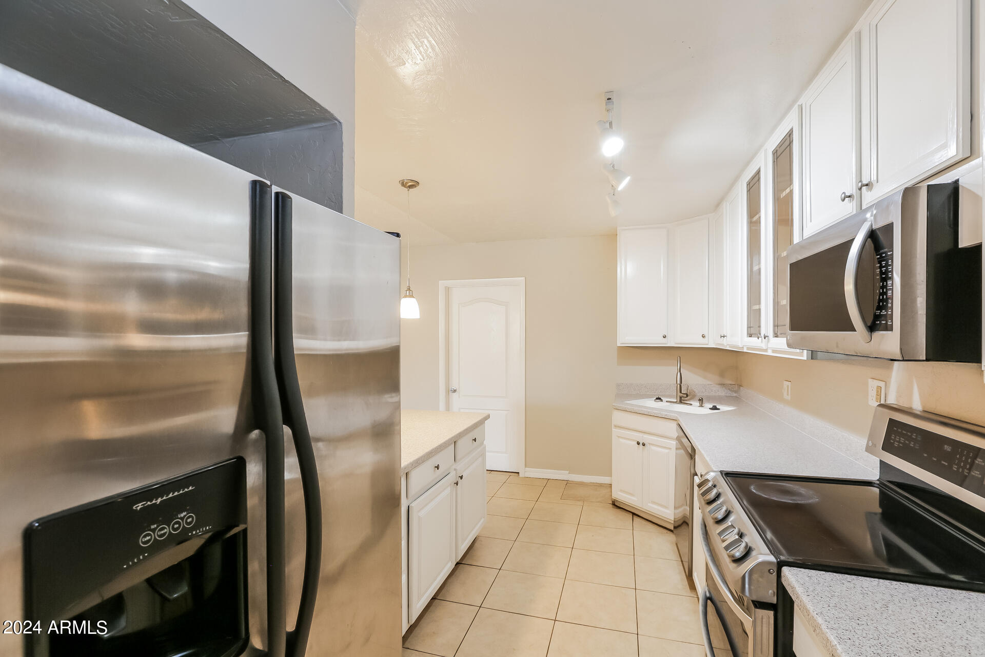 6963 West Pierson Street Phoenix, AZ 85033 - Photo 8 of 21 a kitchen with stainless steel appliances a stove a sink and a refrigerator