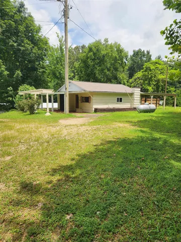 a view of a swimming pool with a yard and a fountain