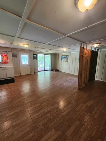 a view of a livingroom with an empty room and wooden floor