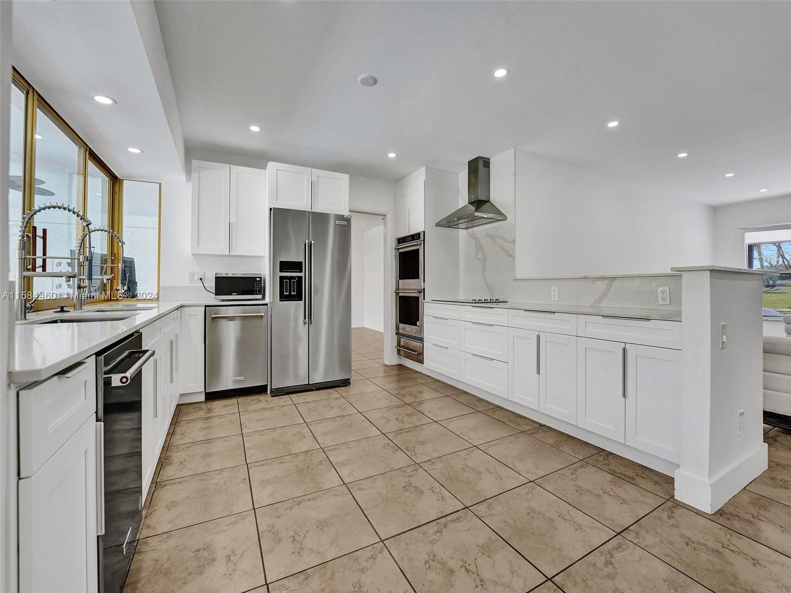 3460 North 46th Avenue Hollywood, FL 33021 - Photo 11 of 35 a kitchen with white cabinets and stainless steel appliances