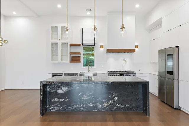 a kitchen with stainless steel appliances granite countertop a stove a sink and a refrigerator