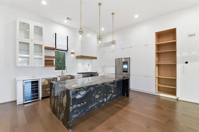 a open kitchen with stainless steel appliances granite countertop a stove and a refrigerator
