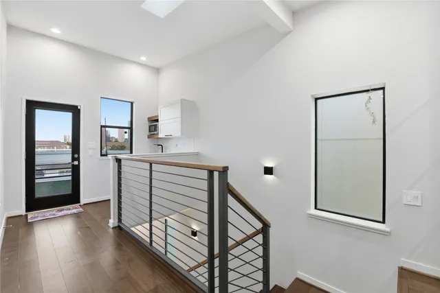 a view of a hallway with wooden floor and cabinet