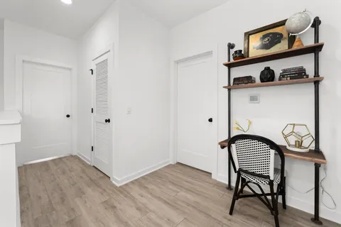 a view of a hallway with wooden floor and a chair