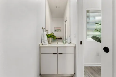 a bathroom with a sink and mirror with window