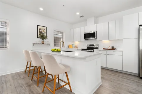 a kitchen with a dining table chairs and cabinets