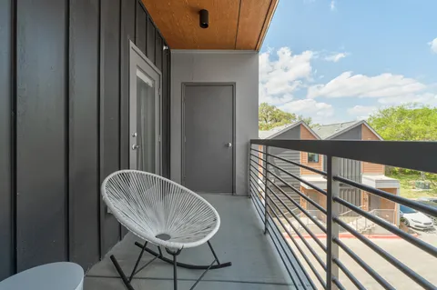 a balcony view with a large window and wooden floor