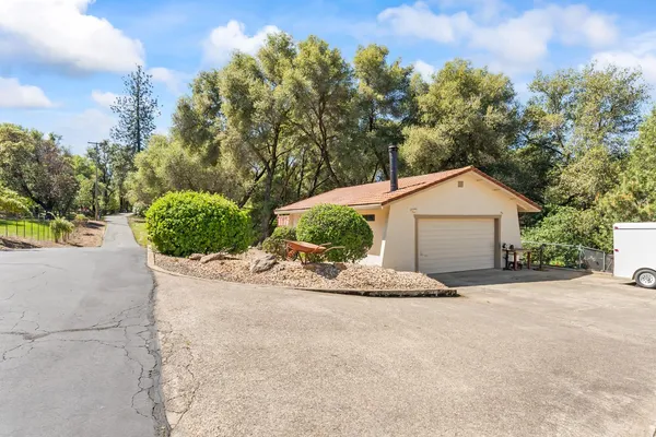 a view of a house with a yard and large tree