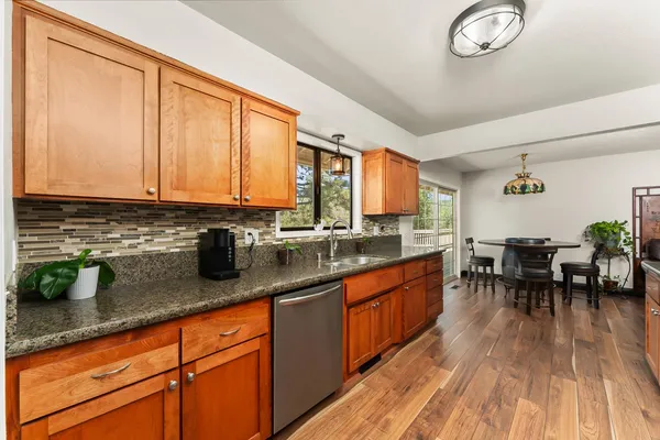 a kitchen with stainless steel appliances granite countertop sink stove top oven and cabinets