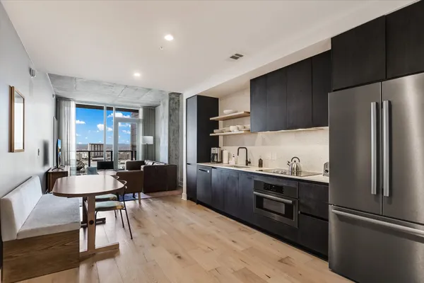 a kitchen with kitchen island a counter top space cabinets and stainless steel appliances