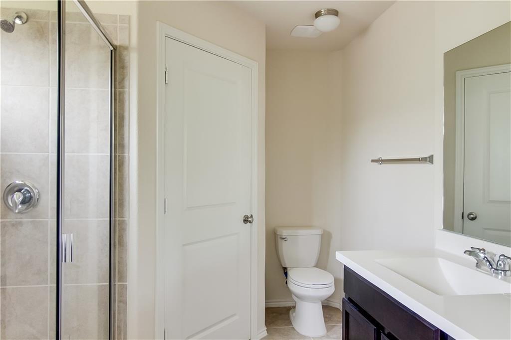 5916 Kennedy Street Austin, TX 78747 - Photo 11 of 25 Bathroom featuring a shower stall, vanity, and light tile patterned floors