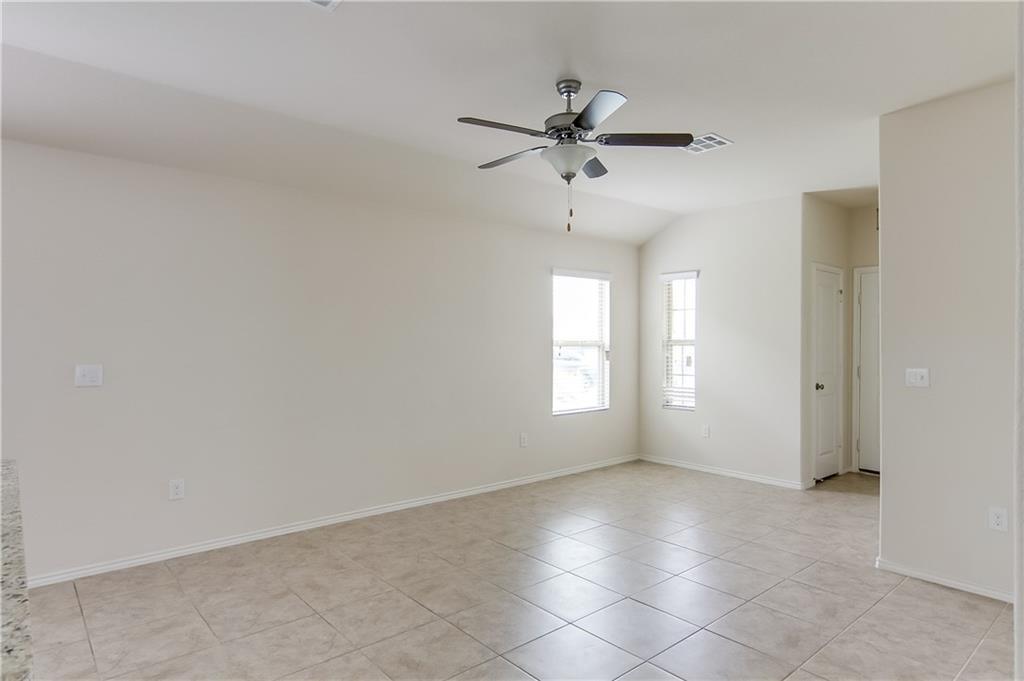 5916 Kennedy Street Austin, TX 78747 - Photo 12 of 25 Unfurnished room with ceiling fan, vaulted ceiling, and light tile patterned floors