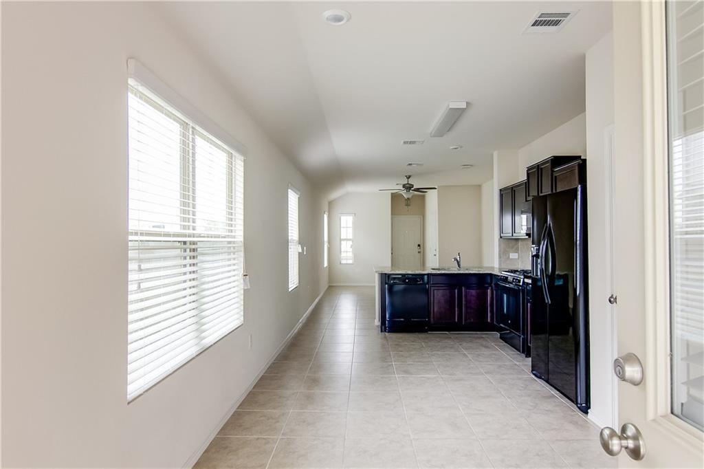 5916 Kennedy Street Austin, TX 78747 - Photo 25 of 25 Kitchen featuring black appliances, a peninsula, light tile patterned flooring, open floor plan, and ceiling fan