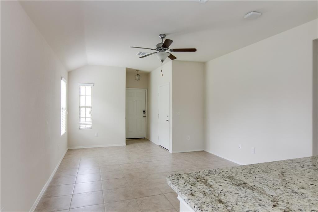 5916 Kennedy Street Austin, TX 78747 - Photo 4 of 25 Unfurnished room with ceiling fan, light tile patterned floors, and lofted ceiling