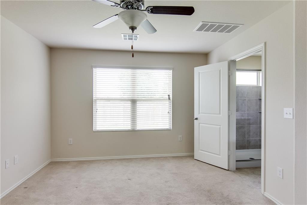 5916 Kennedy Street Austin, TX 78747 - Photo 9 of 25 Unfurnished bedroom with light carpet, ensuite bath, and ceiling fan