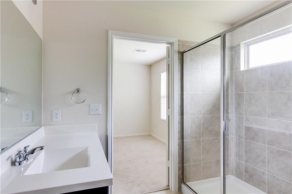 5916 Kennedy Street Austin, TX 78747 - Photo 10 of 25 Bathroom with vanity, plenty of natural light, light colored carpet, and a stall shower