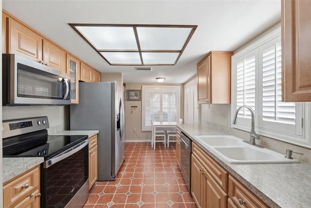 11541 Orleans Lane Port Richey, FL 34668 - Photo 14 of 53 a kitchen with stainless steel appliances granite countertop a sink a stove a refrigerator cabinets and a dining table