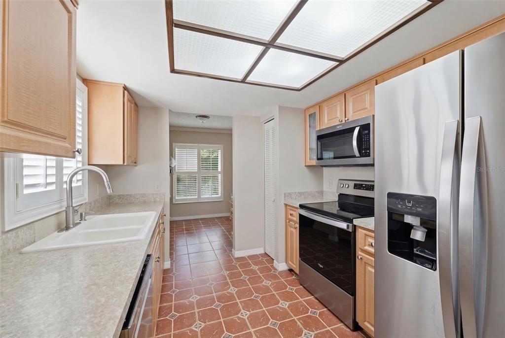 11541 Orleans Lane Port Richey, FL 34668 - Photo 15 of 53 a kitchen with stainless steel appliances granite countertop a refrigerator a stove top oven a sink and dishwasher