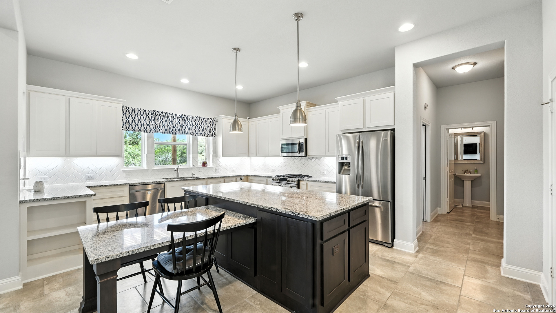 179 Prairie Dawn Spring Branch, TX 78070 - Photo 11 of 45 a kitchen with stainless steel appliances granite countertop a table chairs refrigerator and microwave