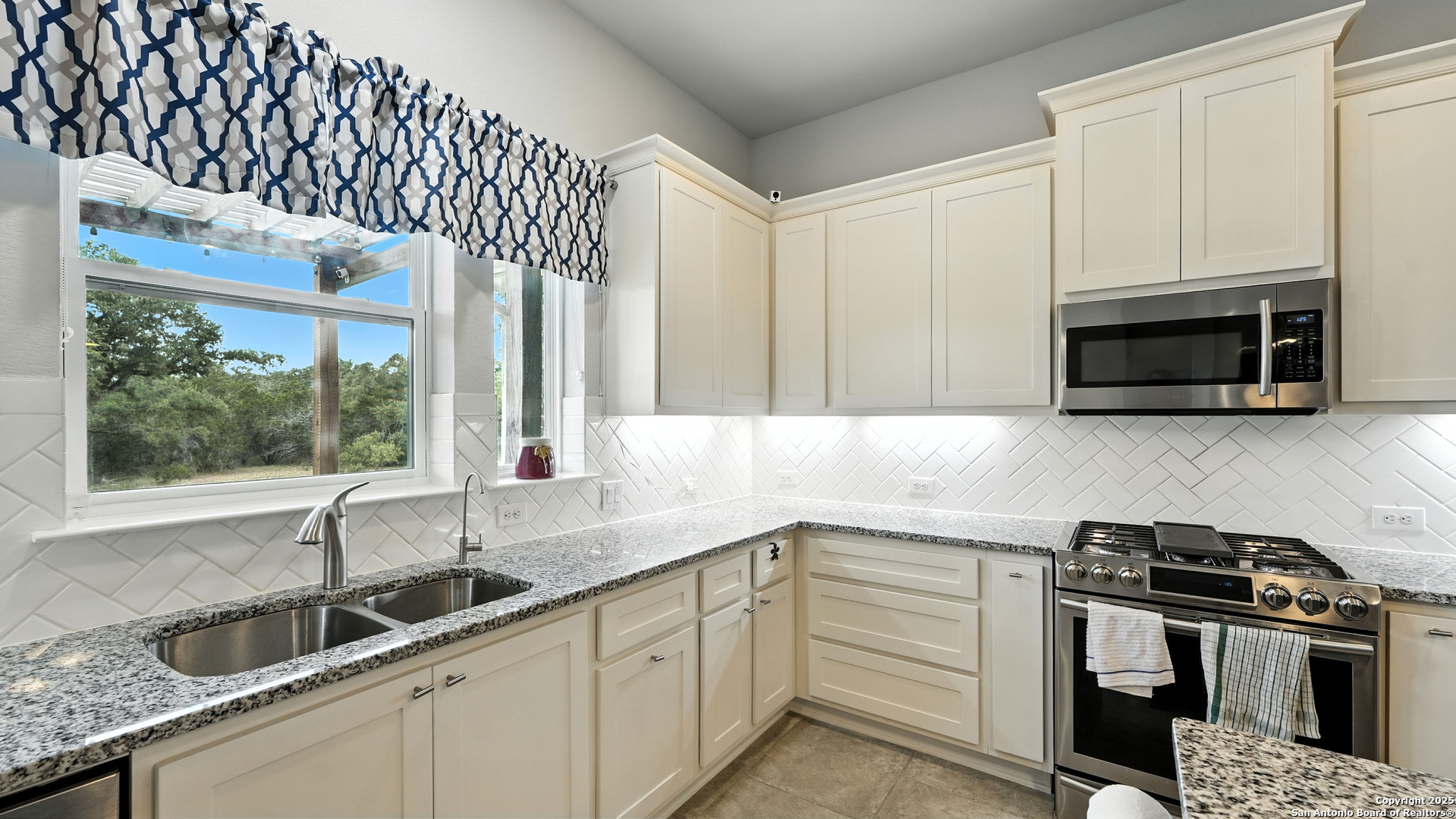 179 Prairie Dawn Spring Branch, TX 78070 - Photo 6 of 45 a kitchen with granite countertop a sink stainless steel appliances wooden floor and a window