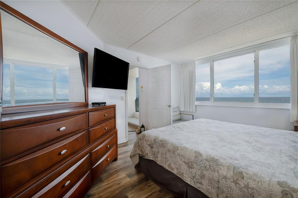 4453 South Atlantic Avenue, Unit 604 Ponce Inlet, FL 32127 - Photo 12 of 28 a bedroom with a bed and a flat tv screen on dresser