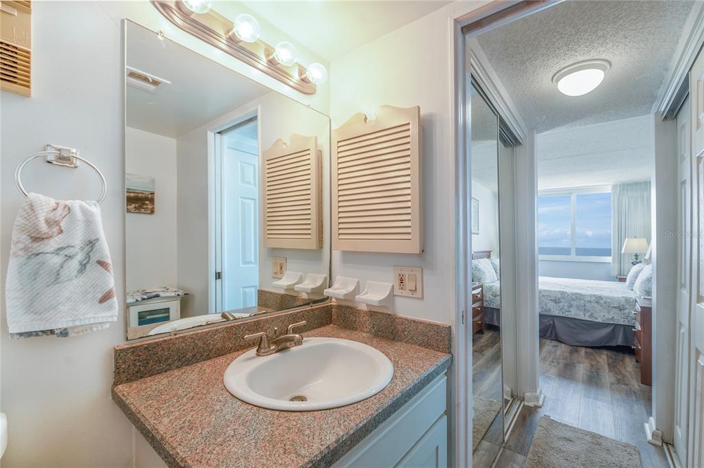 4453 South Atlantic Avenue, Unit 604 Ponce Inlet, FL 32127 - Photo 14 of 28 a bathroom with a granite countertop sink and a mirror