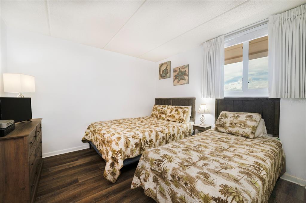 4453 South Atlantic Avenue, Unit 604 Ponce Inlet, FL 32127 - Photo 17 of 28 a bedroom with two beds and a flat screen tv