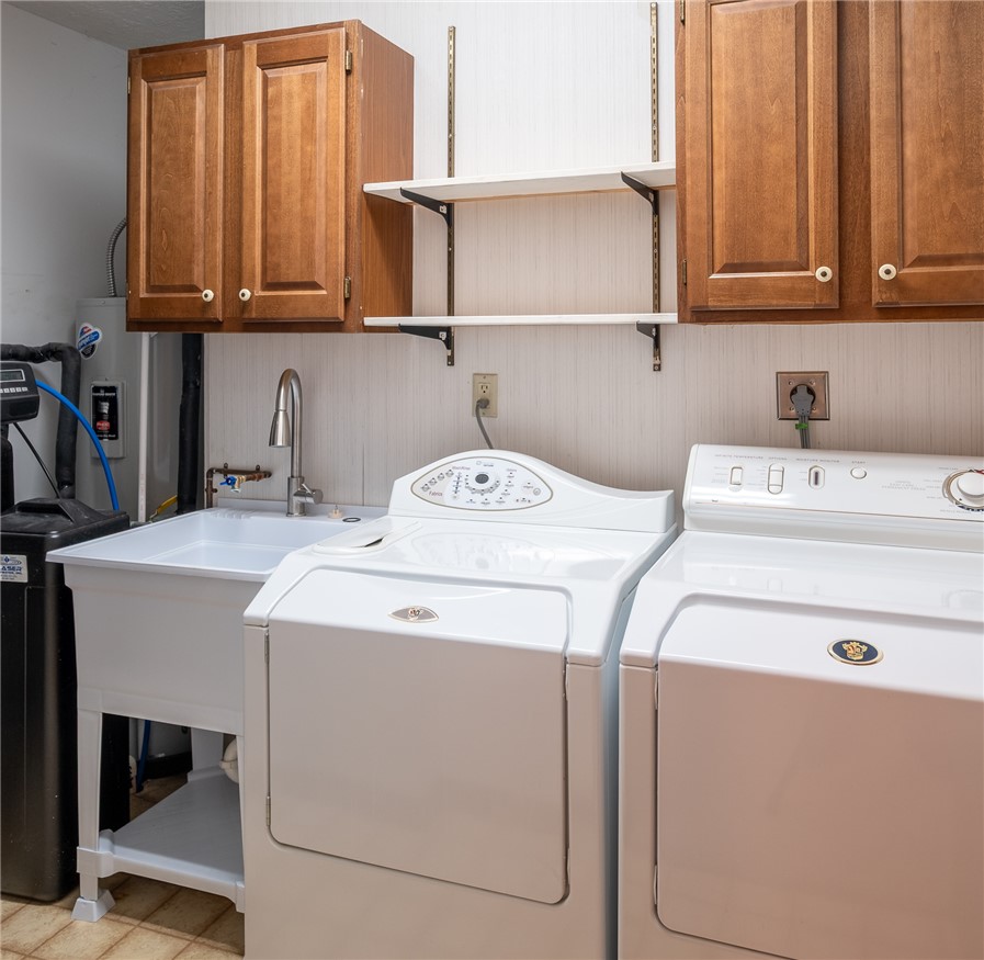 276 South Fairfield Road Bellbrook, OH 45305 - Photo 20 of 38 Conveniently located laundry area with ample storage and utility sink for everyday tasks.