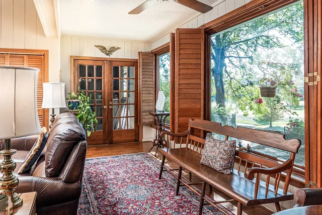 a living room with furniture a bookshelf and a large window