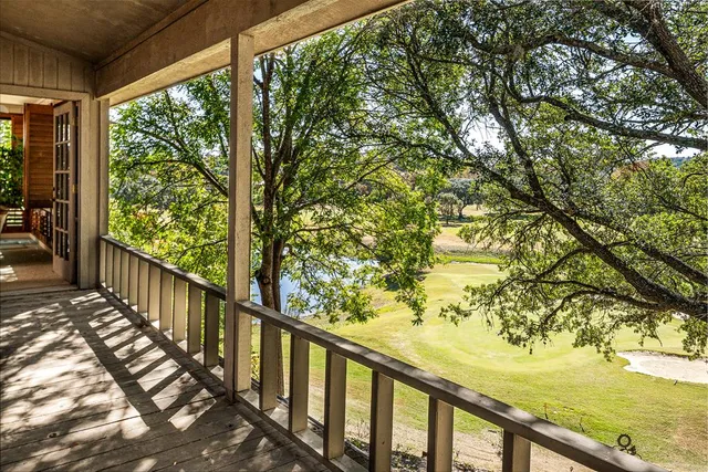 a view of a balcony with wooden floor and fence