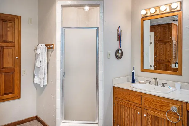 a bathroom with a shower sink and mirror