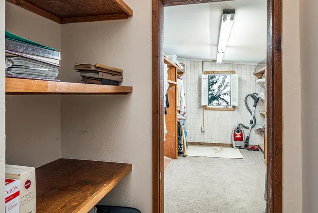 a view of walk in closet with clothes and shoes