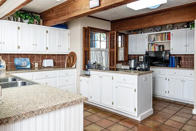 a kitchen with granite countertop white cabinets and white appliances