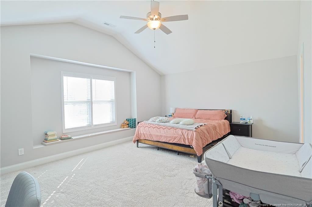 7810 Rufus Johnson Road St. Pauls, NC 28384 - Photo 12 of 24 a spacious bedroom with a bed and a chandelier